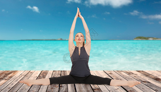 人,健康,健康运动快乐的轻妇女瑜伽姿势木地板上的海洋蓝天背景图片