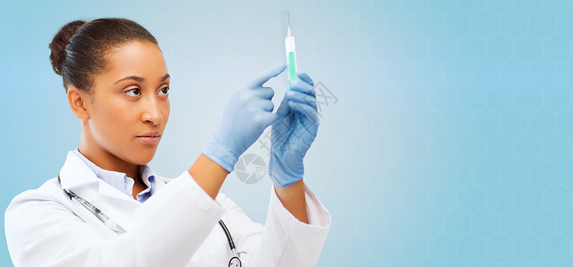 医疗保健,疫苗接种,麻醉医疗非裔美国女医生着注射器,蓝色背景下注射图片