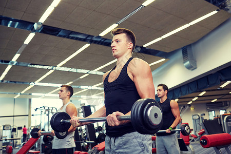 运动,健美,生活方式人的群杠铃弯曲肌肉的男人健身房图片