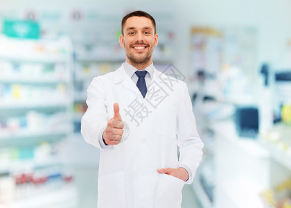 医药,药房,人,保健药理学的微笑的男药剂师穿着白色外套,药店的背景上竖大拇指图片
