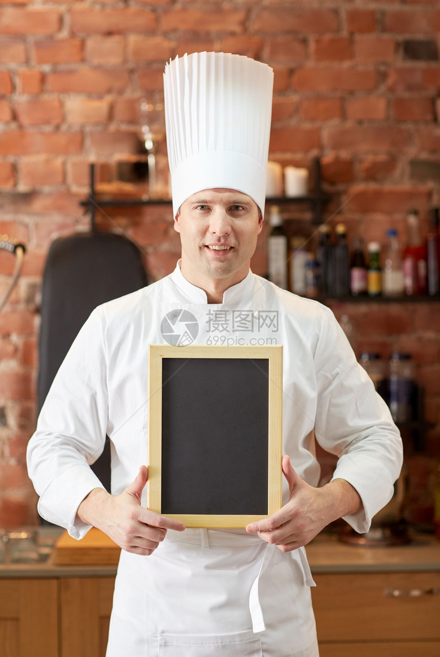 烹饪人的快乐的男厨师与黑色空白菜单粉笔板厨房餐厅厨房图片
