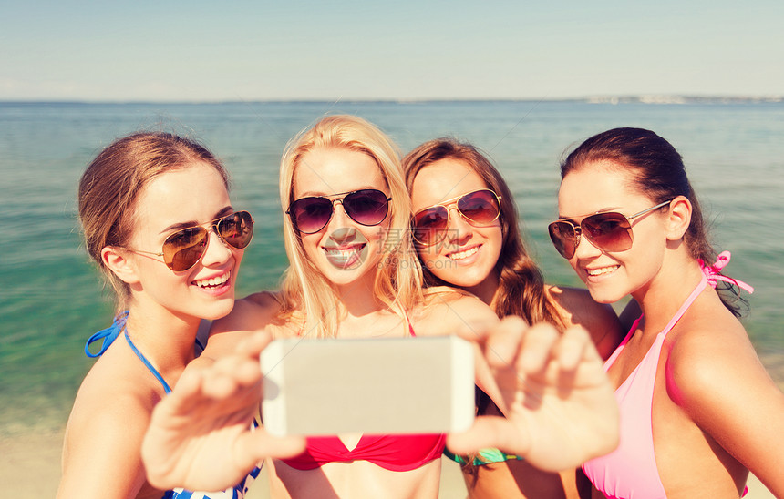 暑假,假期,旅行,技术人的群微笑的轻女海滩上用智能手机蓝天背景下自拍图片