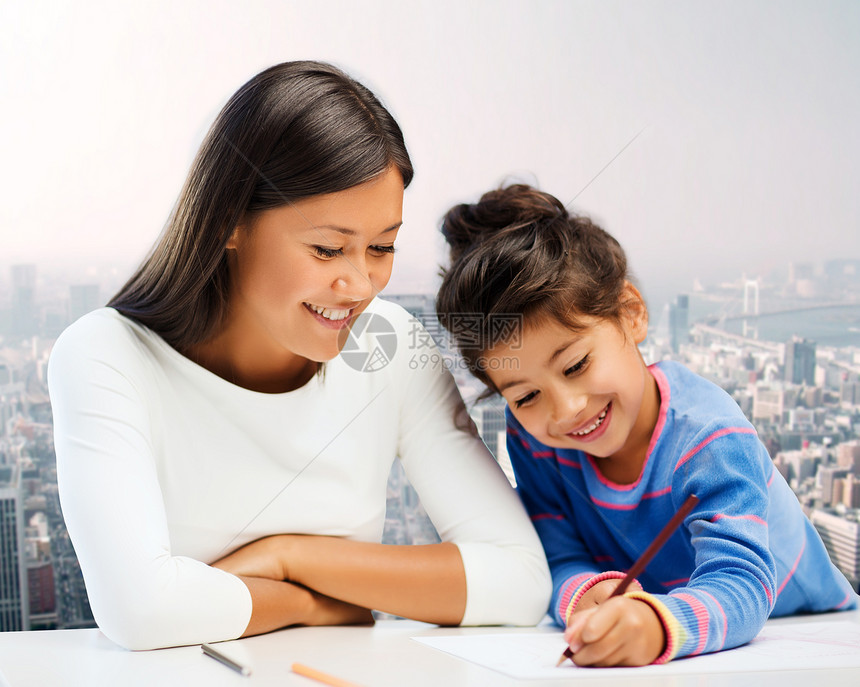 家庭孩子创造力快乐的人的快乐的母亲女儿城市背景下用铅笔画画图片