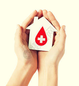 医疗保健医药献血双手牵手,着白色纸屋,红色的捐献者标志背景图片