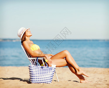 暑假假期女孩穿着比基尼海滩椅子上晒太阳女孩沙滩椅上晒太阳图片