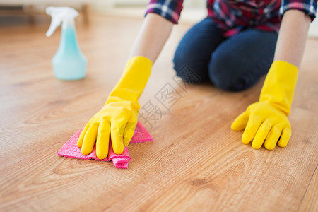 人,家务家务妇女橡胶手套与布洗涤剂喷雾清洁地板家里高清图片