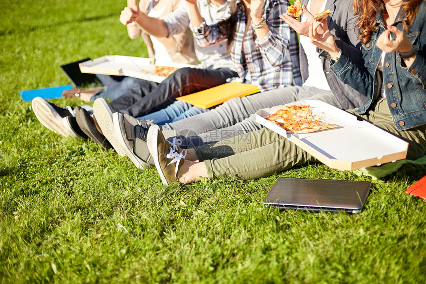教育,食物,人友谊的快乐的十几岁的学生吃比萨饼坐草地上图片