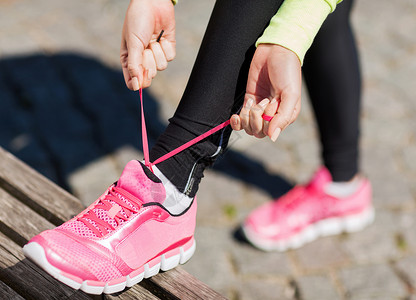 运动,健身,运动生活方式的跑步妇女系鞋带运动鞋图片