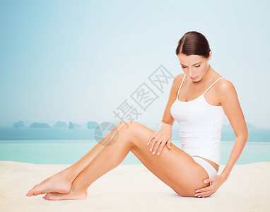 人,美,水疗度假美丽的女人穿着棉质内衣,触摸她的臀部无限的边缘游泳池背景图片