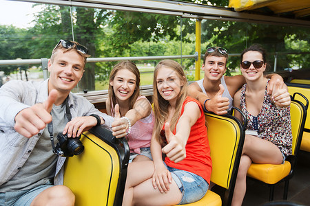 友谊,旅行,假期,夏天人的群快乐的朋友用数码相机乘旅游巴士旅行,竖大拇指图片