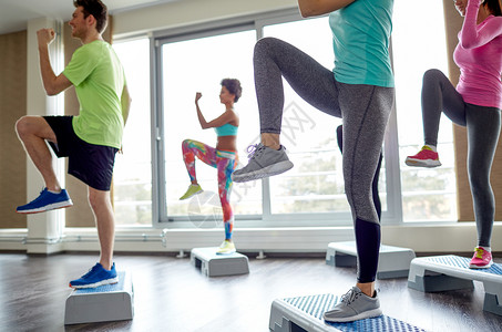 健身,运动,健美操人的群微笑的人健身房的台阶平台上锻炼抬腿图片
