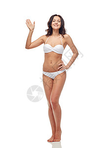 人,时尚,泳装,夏天海滩的快乐的轻女人穿着白色比基尼泳衣挥手图片