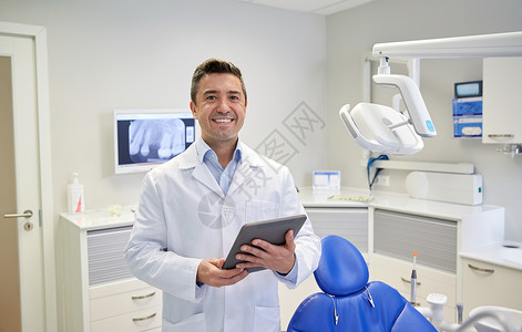 人,医学,口腔医学保健快乐的中男牙医穿着白色外套与平板电脑牙科诊所办公室图片