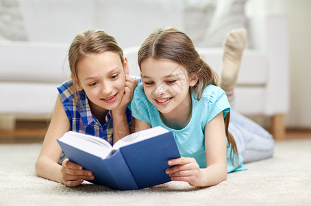 人,孩子,朋友,文学友谊的两个快乐的女孩躺地板上,家看书图片