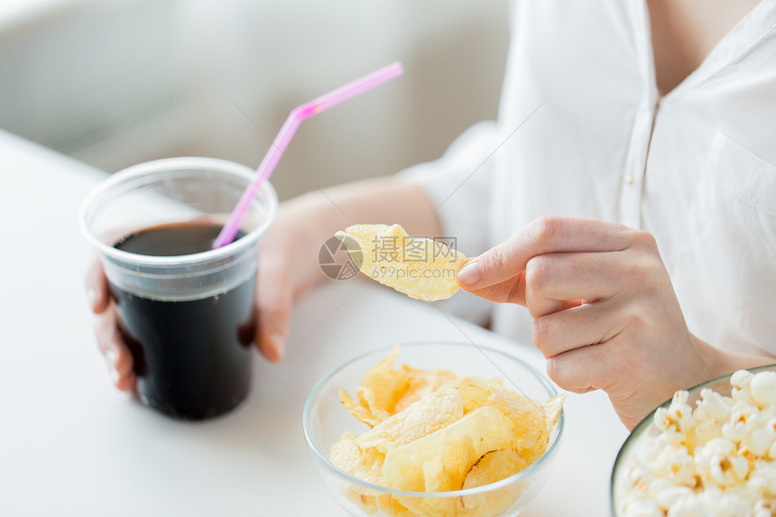 人们,快餐,垃圾食品健康的饮食观念密切妇女与爆米花,玉米片玉米薯片花生碗里图片