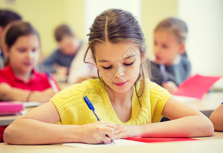 教育,小学,学人的群学校的孩子课堂上用钢笔笔记本写作测试图片