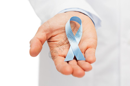 医疗保健,专业,人医学理念近距离男医生手握天蓝色前列腺癌意识丝带背景图片