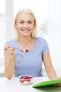 健康的饮食,饮食人们的微笑的轻妇女与平板电脑家里吃水果沙拉图片