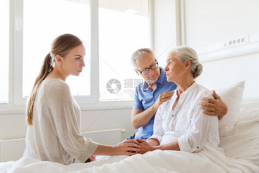 医学,支持,家庭保健人的老男子轻妇女访问欢呼她生病的祖母医院病房图片