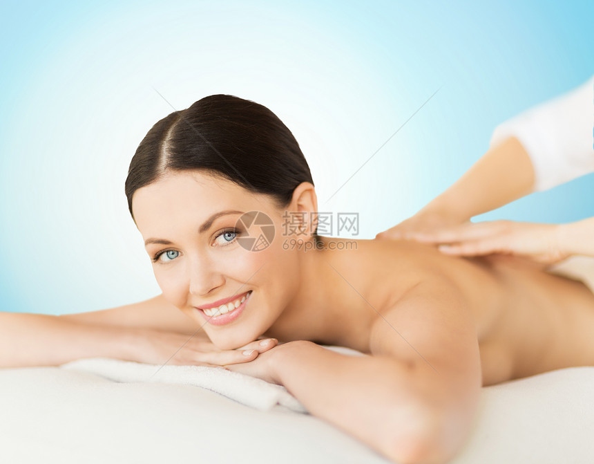 人,美容,水疗身体护理快乐的美丽女人背部按摩蓝色背景图片