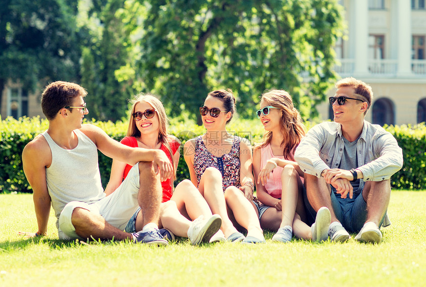 友谊,休闲,夏天人的群微笑的朋友户外坐公园的草地上图片