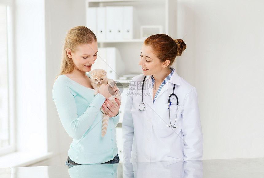 快乐的女人兽医医生用听诊器检查苏格兰折叠小猫兽医诊所图片