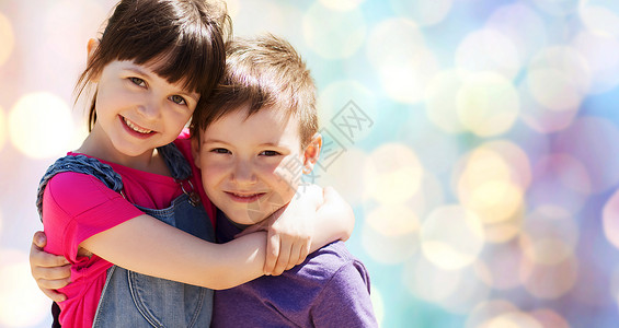快乐的孩子拥抱蓝色的灯光背景图片