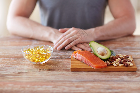 富胶鱼健康的饮食,饮食人的密切的男手与食物富含蛋白质的砧板桌子上背景