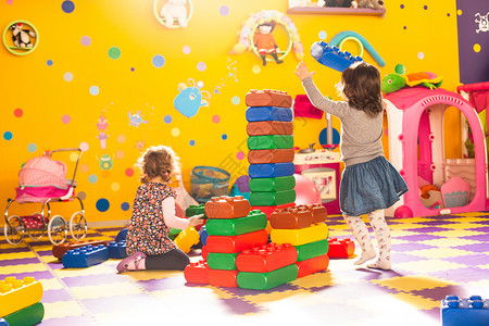 两个女孩游戏室里玩大砖块图片