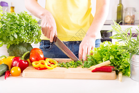 女的手厨房的木板上准备蔬菜沙拉图片