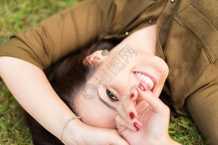 微笑的女人躺草地上图片