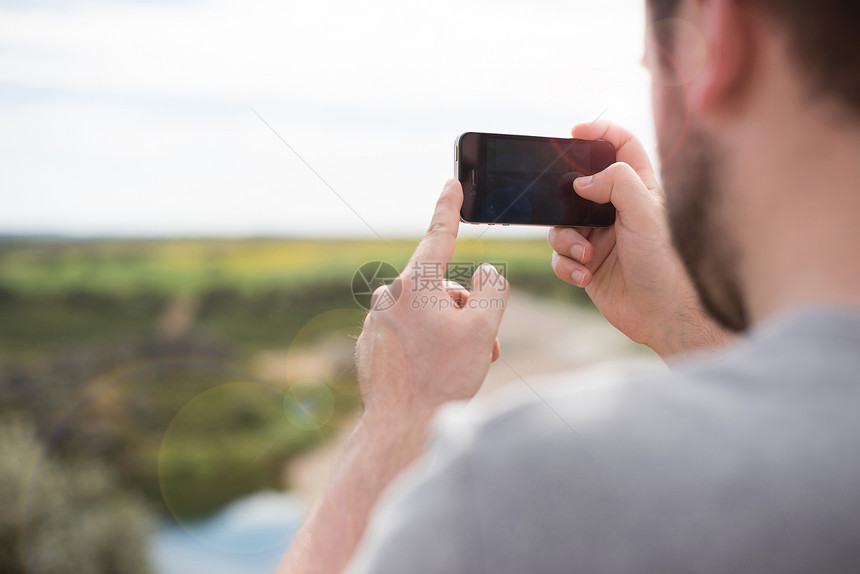男人用智能手机相机拍照图片