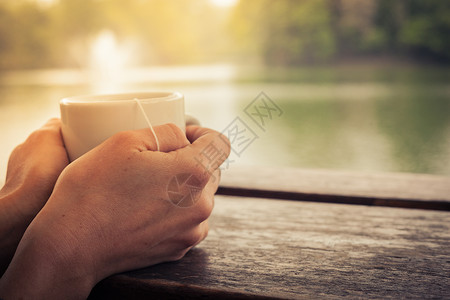 下午的湖边,女士拿着杯茶图片