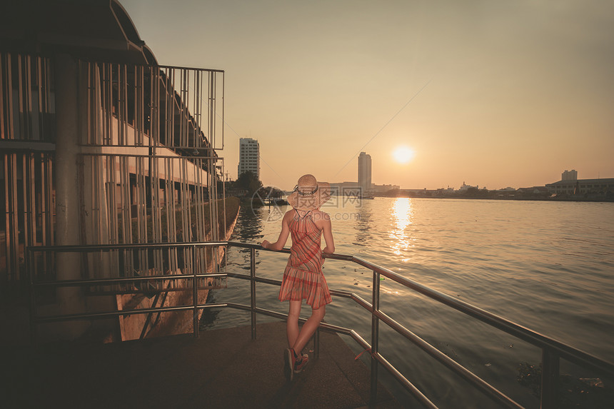 泰国曼谷,位轻的女人正河边欣赏日落图片
