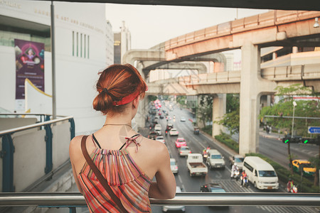 个轻的女人正看曼谷立交桥上的交通图片