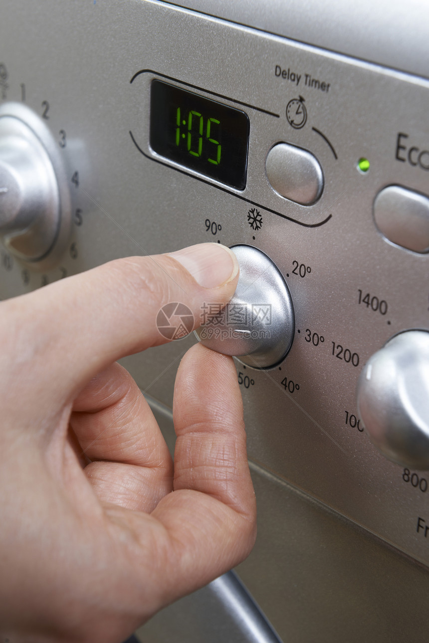 妇女选择洗衣机的冷却器温度,以节省能源图片