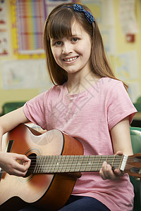 女孩学校音乐课上学弹吉他背景图片