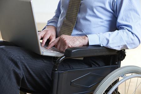 轮椅上的残疾商人用笔记本电脑图片