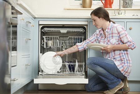 嵌入式洗碗机女人厨房里装洗碗机背景