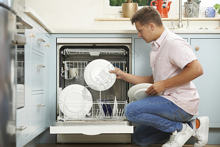男人厨房里装洗碗机背景图片