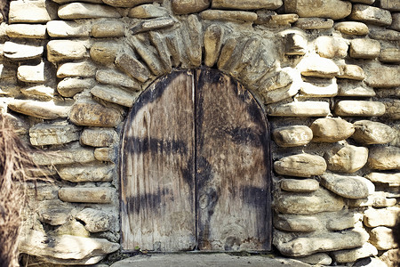 古老的拱形窗户石墙上,中世纪风格的木制百叶窗图片