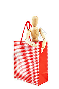穿着红色礼品袋的小木头人被隔离白色的背景上图片