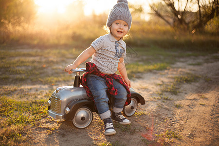 小档口蹒跚学步的孩子用玩具赛车摆姿势背景