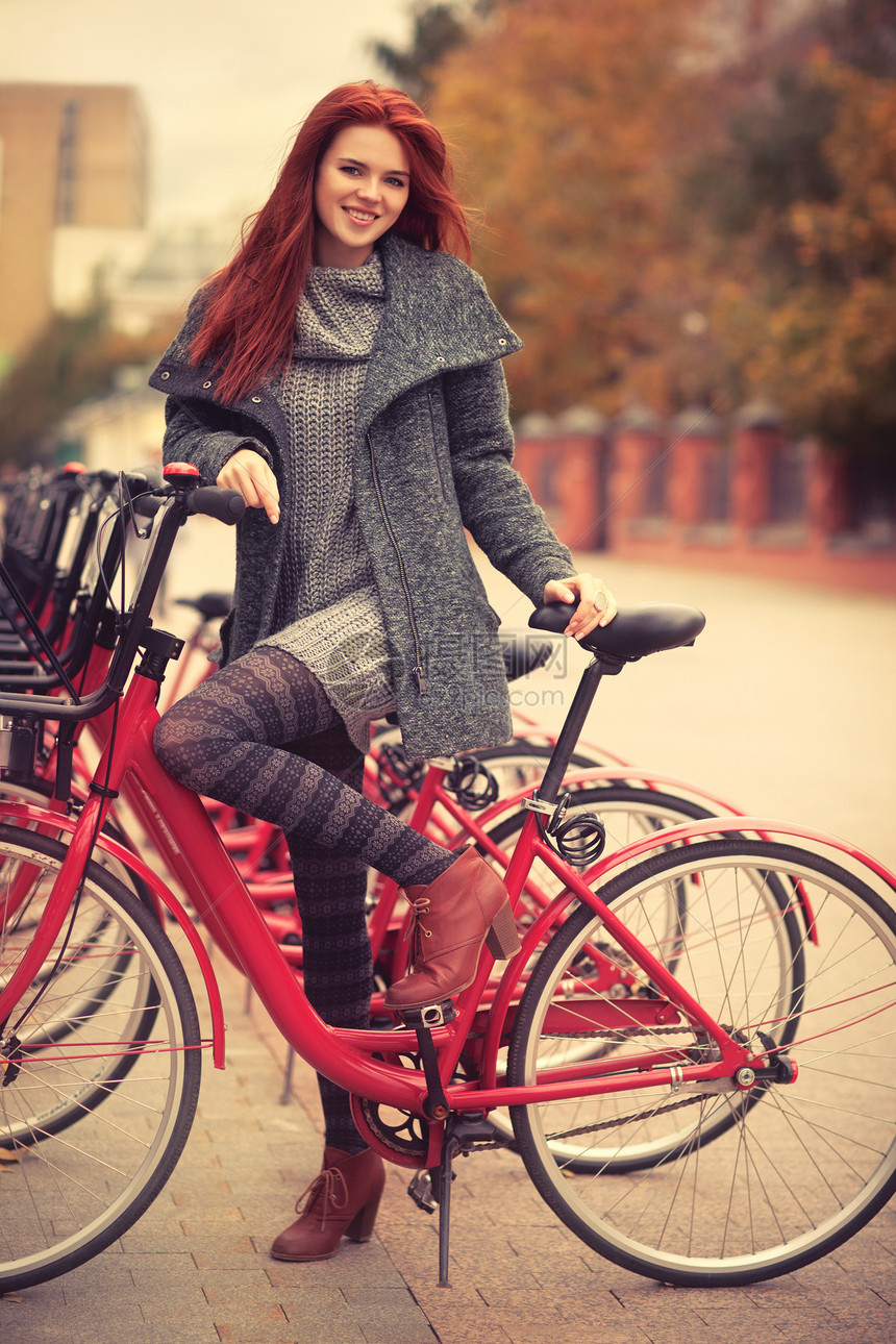 站城市自行车旁的轻女人图片