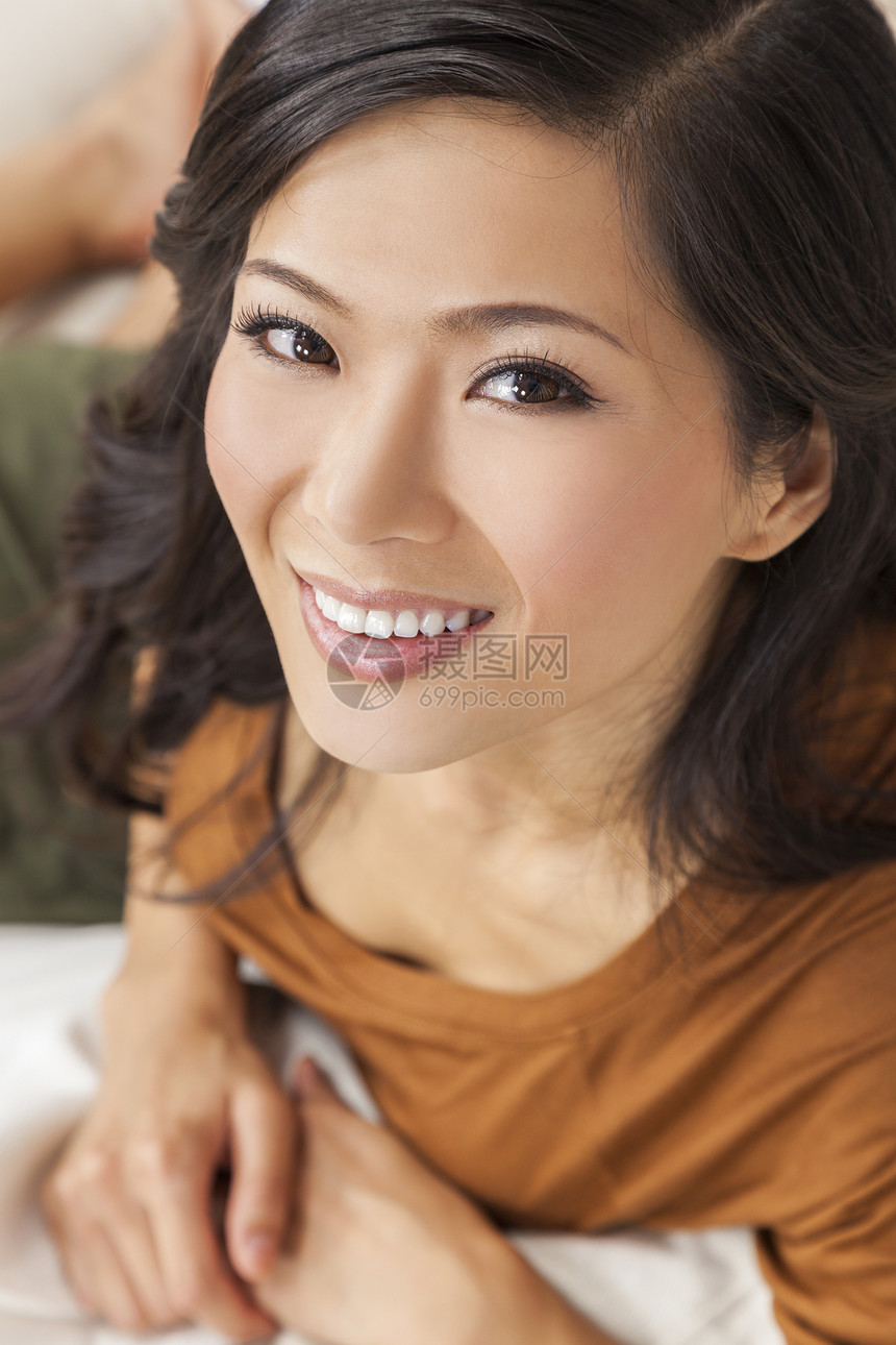 个美丽的轻的中国亚洲东方女人,着美妙的牙齿微笑图片