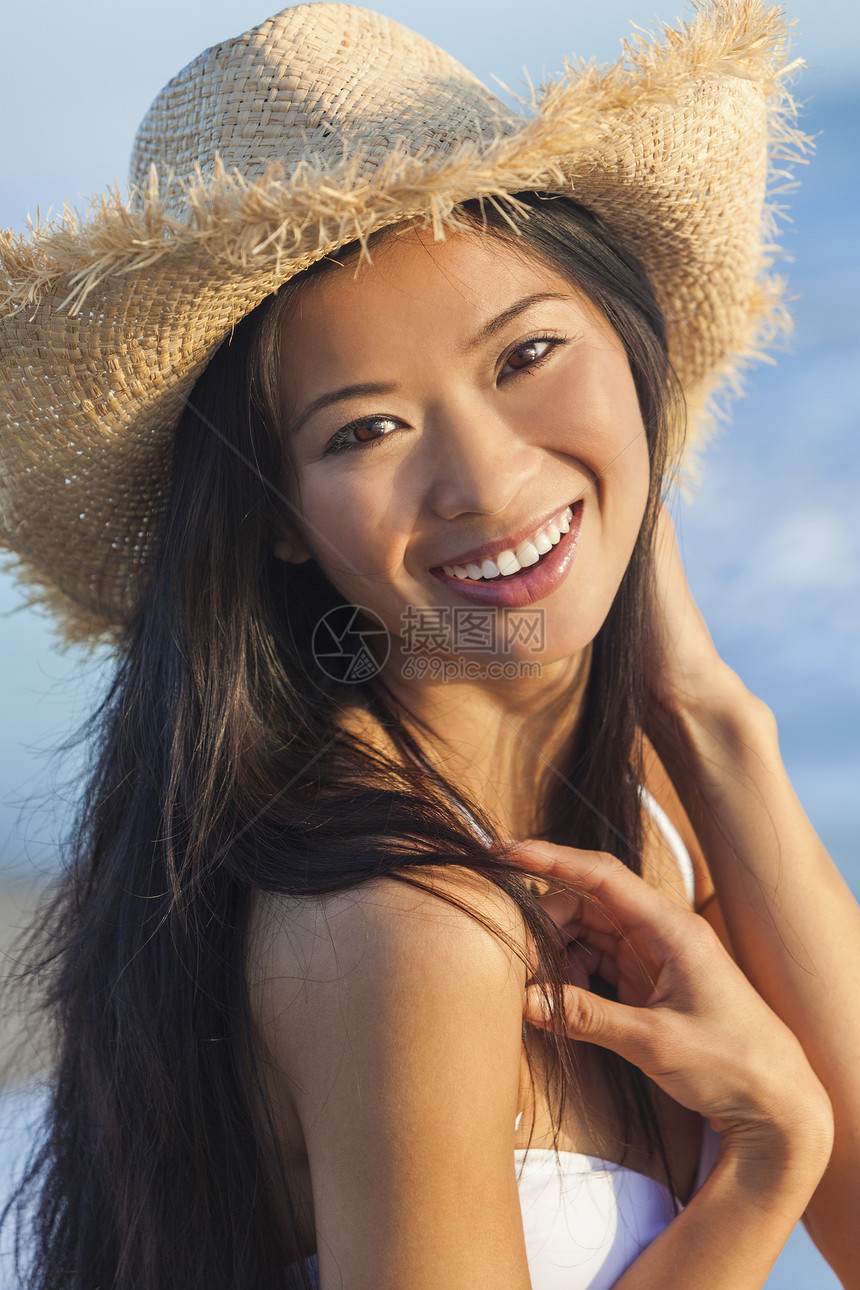 位美丽的中国亚洲轻妇女女孩海滩上穿着白色比基尼稻草牛仔帽的户外肖像图片