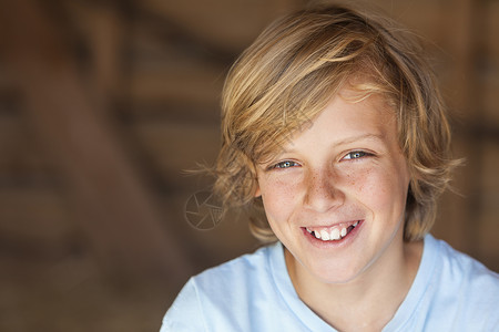 轻快乐微笑的金发男孩,大约12岁早期青少图片