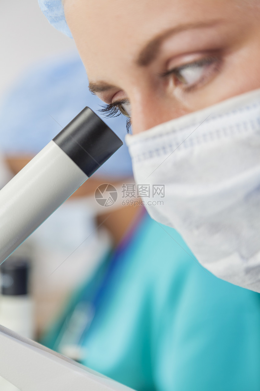 用她的显微镜她身后的亚洲同事近距离观察美丽的女医学科学研究员实验室医生图片