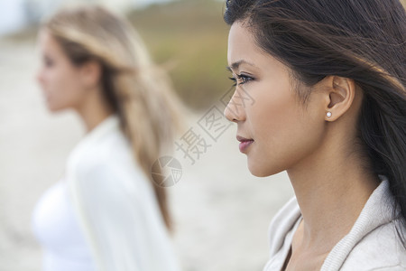 户外轮廓肖像,个美丽的体贴的中国亚洲轻妇女女孩与金发女朋友海滩图片