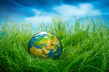 地球仪躺绿色的草地上地球日图片